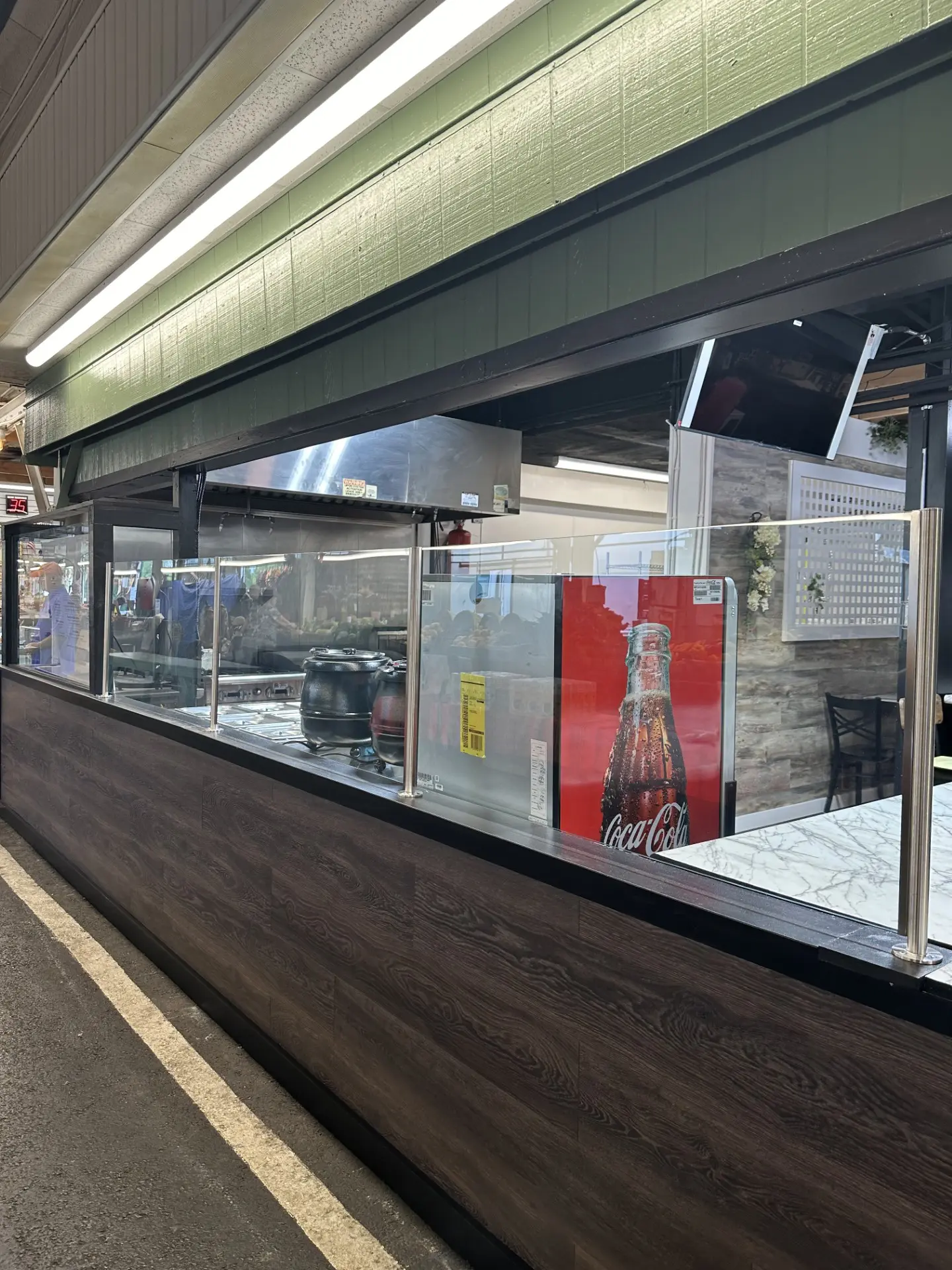 A subway station with a glass wall and a wooden floor.