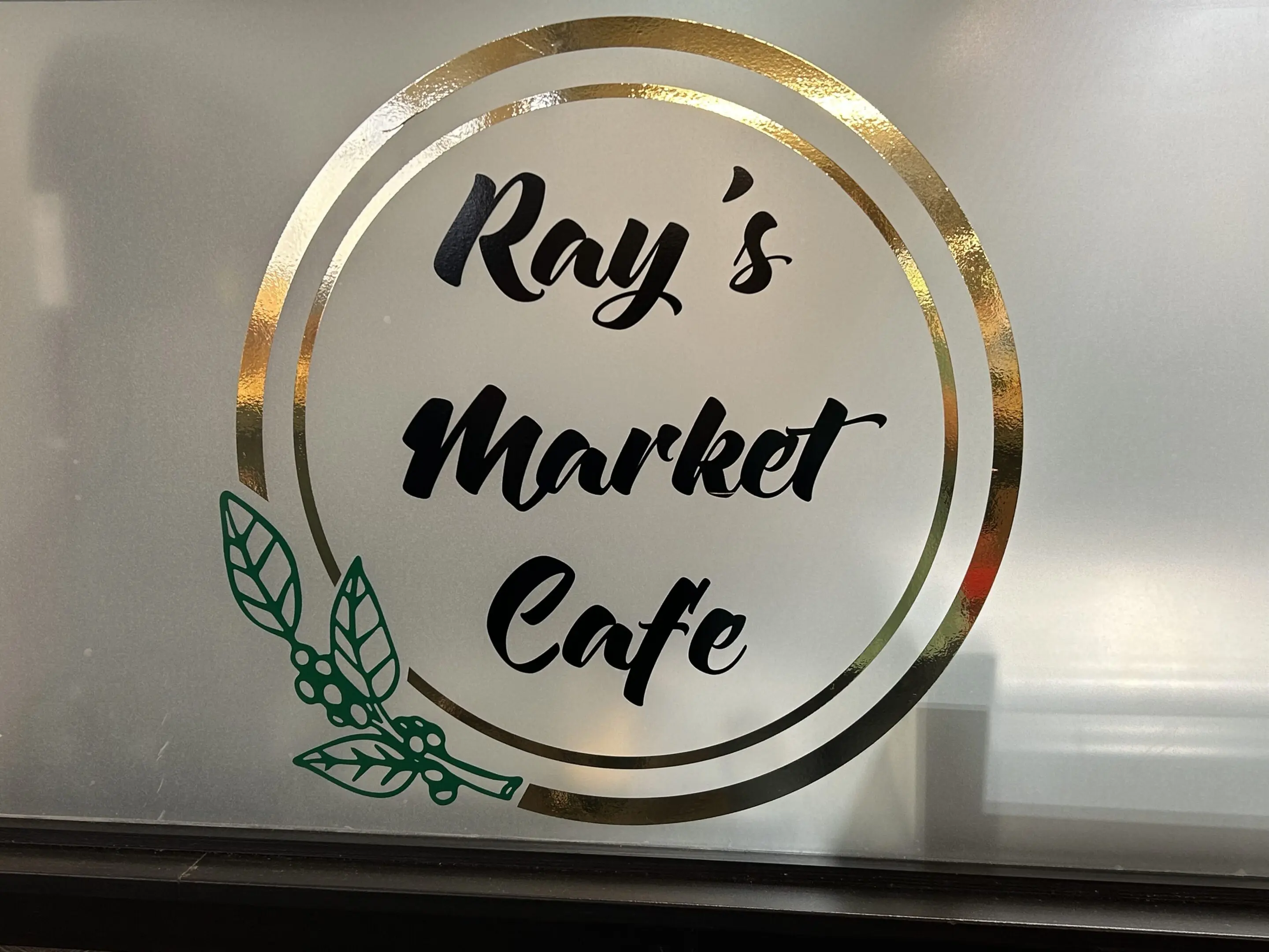 A window sign that says ray 's market cafe.